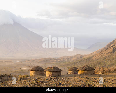 Villaggio masai di fronte all'Ol Doinyo Lengai (montagna di Dio nel Maasai lingua), Tanzania Africa. Foto Stock