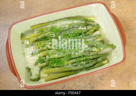 Gli asparagi verdi in piastra su sfondo di pietra Foto Stock