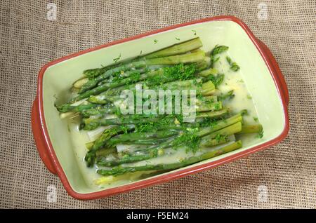 Zuppa di asparagi in piastra su sfondo di iuta Foto Stock