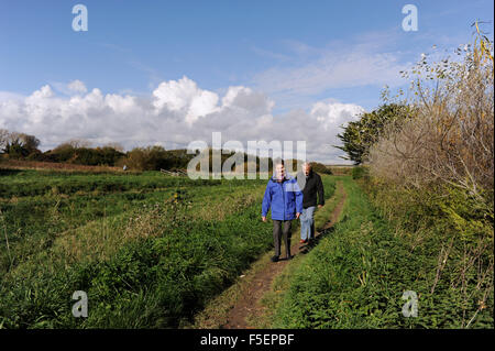 Anziani senior coppia matura di andare a fare una passeggiata lungo il fiume Rife in Ferring vicino a Worthing SUSSEX REGNO UNITO Foto Stock