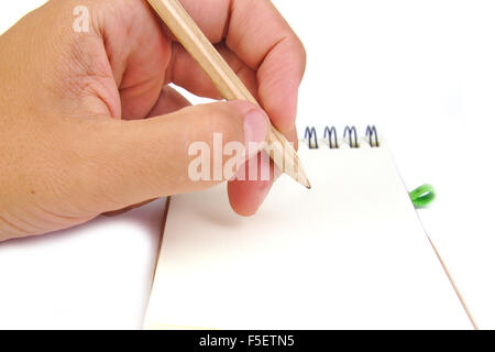 Mano con matita prendere appunti in un notebook su sfondo bianco Foto Stock