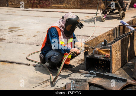 Lavoratore di saldatura trave in acciaio sul sito in costruzione, Bangkok, Thailandia Foto Stock