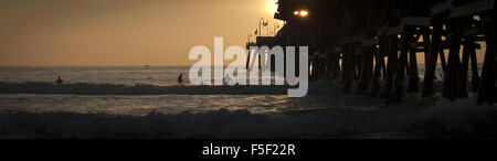 San Clemente, California, Stati Uniti d'America. 9 Dic 2012. Tre surfers condividono un tramonto sessione di surf in acqua appena a sud di San Clemente molo nel tardo autunno.--------San Clemente, situato nella parte più a sud della Contea di Orange, è noto per la sua surf e beach culture nonché un clima mite tutto l'anno. © David Bro/ZUMA filo/Alamy Live News Foto Stock