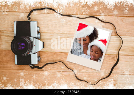 Immagine composita della madre e figlia apertura di un regalo di natale Foto Stock