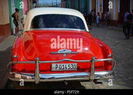 Vintage rosso e bianco auto parcheggiata su una strada tranquilla in Trinidad, Cuba Foto Stock