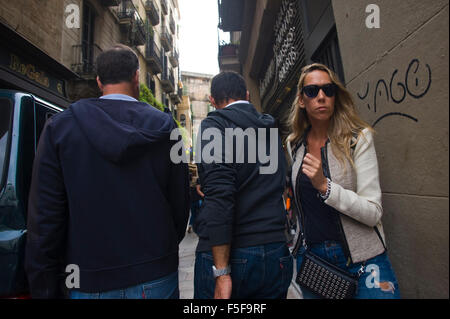 Due uomini camminare per strada stretta passato la donna a Barcellona Catalonia Spagna ES Foto Stock