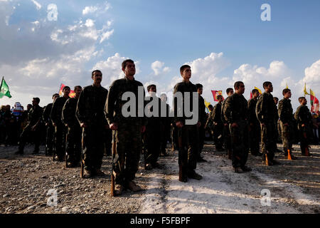 Combattenti curdi del popolo della unità di protezione YPG e la donna della unità di protezione YPJ prendendo parte nella cerimonia di assunzione in Al Hasakah o Hassakeh quartiere noto come Rojava de facto il curdo regione autonoma originari e costituito da tre auto-che disciplinano i cantoni nella Siria settentrionale Foto Stock