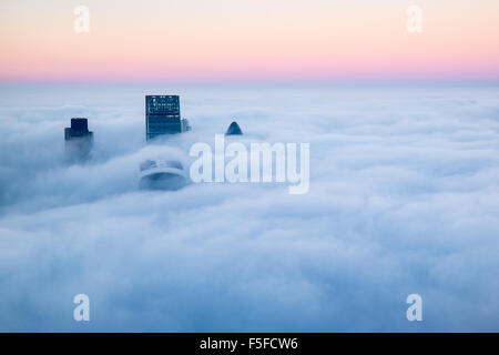 Vista dalla Shard la costruzione di Londra con il paesaggio coperto di nebbia e nube si compone di quattro edifici rottura attraverso il cloud Foto Stock