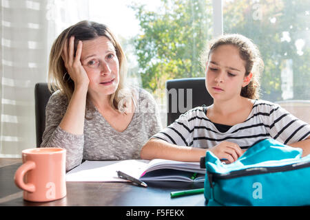 Schoolgirl studiare con i libri sul tavolo della cucina Foto Stock