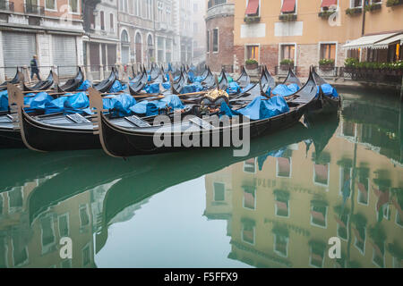 Sleeping gondole in una laguna ancora appena fuori il Canal Grande a Venezia, Italia. Questa è la notte di parcheggio per le barche a fondo piatto. Foto Stock