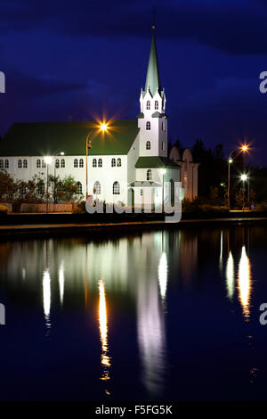 Frikirkjan Chiesa riflessa sul laghetto Tjorning, Reykjavik, Islanda Foto Stock