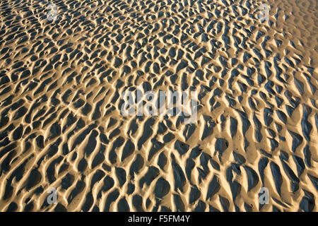 Random artistico naturale pattern creato dal moto ondoso e delle maree azione della natura nella sabbia bagnata in spiaggia Foto Stock