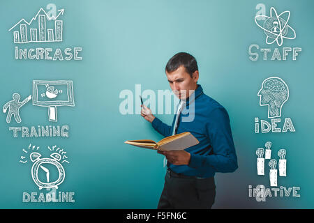 Un uomo in una cravatta e una camicia la lettura di un libro e punti a delineare i Foto Stock