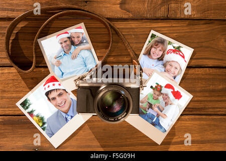 Immagine composita di carino coppia in cappelli di Babbo Natale lo shopping online con il computer portatile Foto Stock