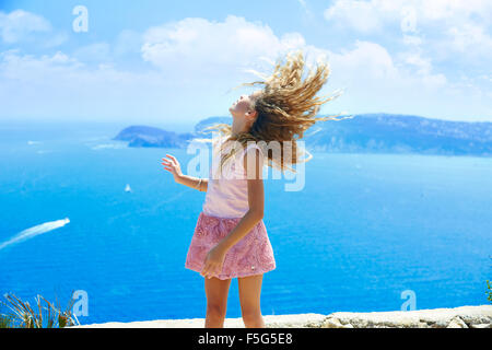 Ragazza bionda scuotendo i capelli in aria a blu mare Mediterraneo turistico in Spagna Foto Stock