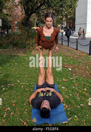 Vestibilità atletica l uomo e la donna fare acro esercizi yoga in Washington Square Park di New York City Foto Stock