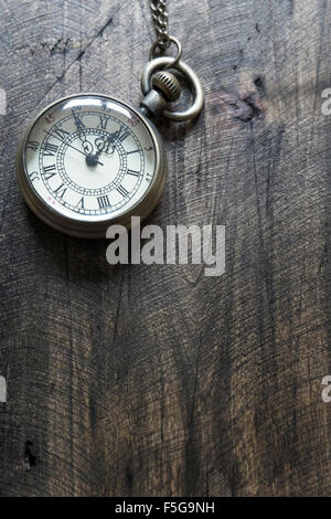 Tempo - Vintage orologio da tasca sul legno stagionato sfondo, dal di sopra Foto Stock