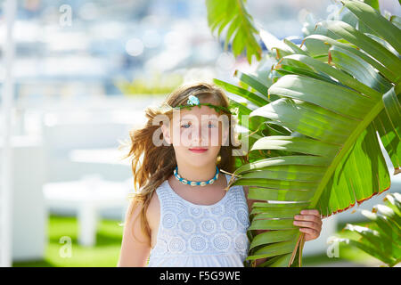 Bionda ragazza di capretto al banana foglie in giornata luminosa luce nel Mediterraneo Foto Stock