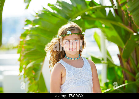 Bionda ragazza di capretto al banana foglie in giornata luminosa luce nel Mediterraneo Foto Stock