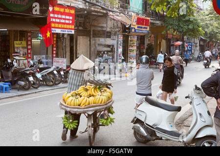 Signora vietnamita la vendita delle banane dalla sua bicicletta in Hanoi old quarter,Vietnam,Asia Foto Stock