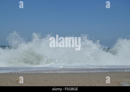 Onde che si infrangono bruscamente formando spray bianco al nero riva del mare in Yalikoy, Catalca, Turchia. Foto Stock