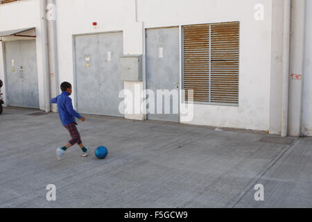 Atene, Grecia. 4 Novembre, 2015. Ragazzo giocare con una palla a Galatsi Olympic Hall di Atene. La struttura in disuso, che utilizzata durante le Olimpiadi di Atene 2004, riaperto un mese fa per i migranti come più di seicentomila persone sono arrivati in Grecia finora questo anno cercando di testa per la più prospera Unione europea paesi del nord. © Aristidis Vafeiadakis/ZUMA filo/Alamy Live News Foto Stock