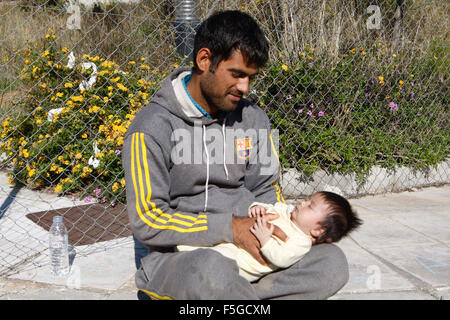 Atene, Grecia. 4 Novembre, 2015. Un padre afgano tiene il suo bambino al Galatsi Olympic Hall di Atene. La struttura in disuso, che utilizzata durante le Olimpiadi di Atene 2004, riaperto un mese fa per i migranti come più di seicentomila persone sono arrivati in Grecia finora questo anno cercando di testa per la più prospera Unione europea paesi del nord. © Aristidis Vafeiadakis/ZUMA filo/Alamy Live News Foto Stock