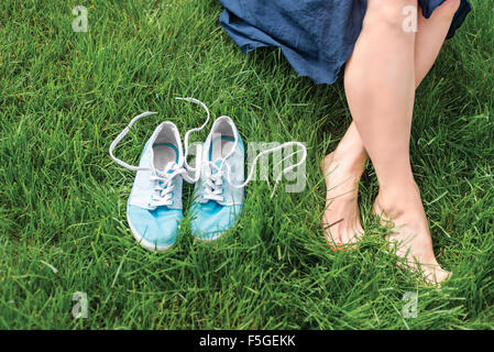 Gambe e sneakers sull'erba Foto Stock