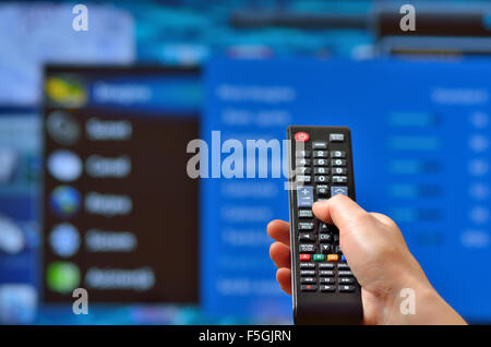 Smart tv e mano, premendo il telecomando Foto Stock