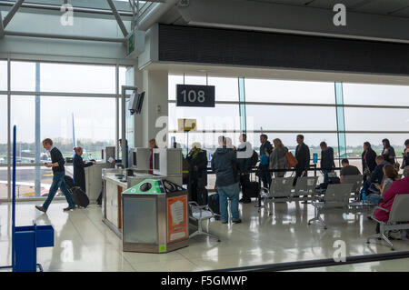 I passeggeri riportano le carte di imbarco e i passaporti al gate di partenza all'aeroporto di Dublino un terminale Foto Stock