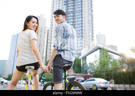 Felice coppia giovane equitazione biciclette Foto Stock