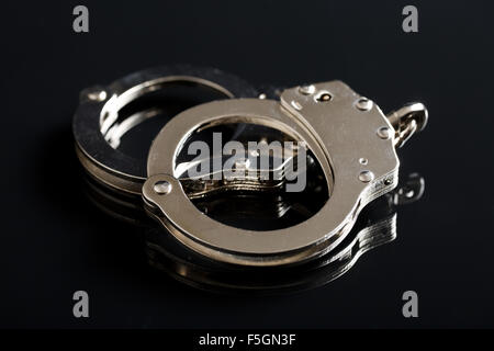 Il argento manette su sfondo nero Foto Stock