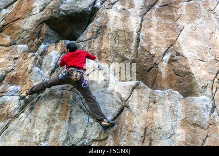 Uomo arrampicatore di montagna che raggiunge, scalatore che sale sulla parete rocciosa, Repubblica Ceca Foto Stock