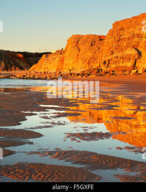 Algarve rocciosa costa dell'oceano al tramonto. Sugres, Portogallo Foto Stock