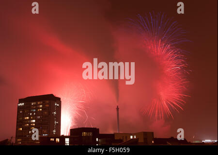 Glasgow, Regno Unito. 04 Nov, 2015. Fuochi d'artificio esplodere in anticipo di un giorno a Glasgow Green per celebrare Guy Fawkes notte con Gorbals appartamenti in primo piano. Credito: Tony Clerkson/Alamy Live News Foto Stock