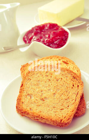 Un set tavolo con differenti piastre con toast, confettura di fragole e burro Foto Stock