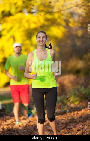 Coppia giovane in esecuzione nella stagione autunnale Foto Stock