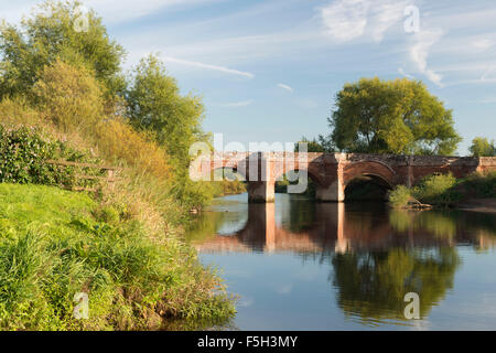 La pietra arenaria medievale ponte che attraversa il fiume Dee tra Inghilterra e Galles a Farndon Foto Stock