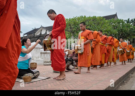 Adoratori di elemosina e cibo per i monaci buddisti a Luang Prabang, Laos Foto Stock