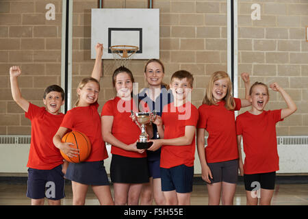 Vittoriosa Scuola di Sport Team con il trofeo in palestra Foto Stock