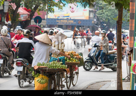 Onorevoli vietnamita per la vendita di frutta da loro biciclette in Hanoi old quarter,città capitale del Vietnam Foto Stock