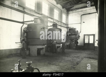 Gli uomini al lavoro di distillazione di solfuro di olio, Italia Foto Stock