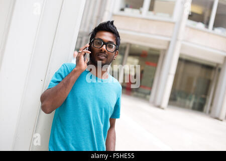 Giovane uomo che parla per il suo telefono cellulare Foto Stock