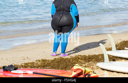 Donna obesa indossando muta ar centro di sport acquatici sulla spiaggia in Spagna