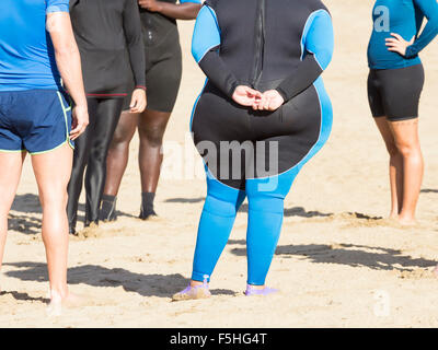 Donna obesa indossando muta ar centro di sport acquatici sulla spiaggia in Spagna