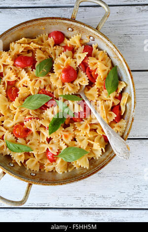 Pasta con pomodori e basilico in vecchi pan Foto Stock