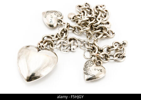 Collana in argento con ciondoli cuore isolato su bianco Foto Stock