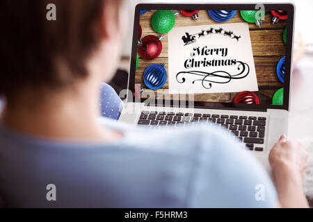 Immagine composita della donna incinta usando il suo computer portatile Foto Stock