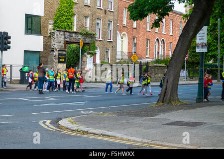 I bambini della scuola i bambini di strada di attraversamento supervisionato Foto Stock