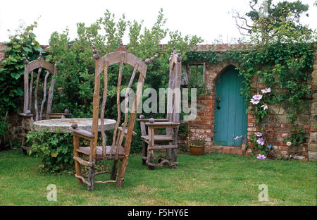 Balcone con tavolo e sedie in legno riciclato riadattato, cuscini, area da  pranzo esterna con patio, viole, succulenti e micro green UK Foto stock -  Alamy